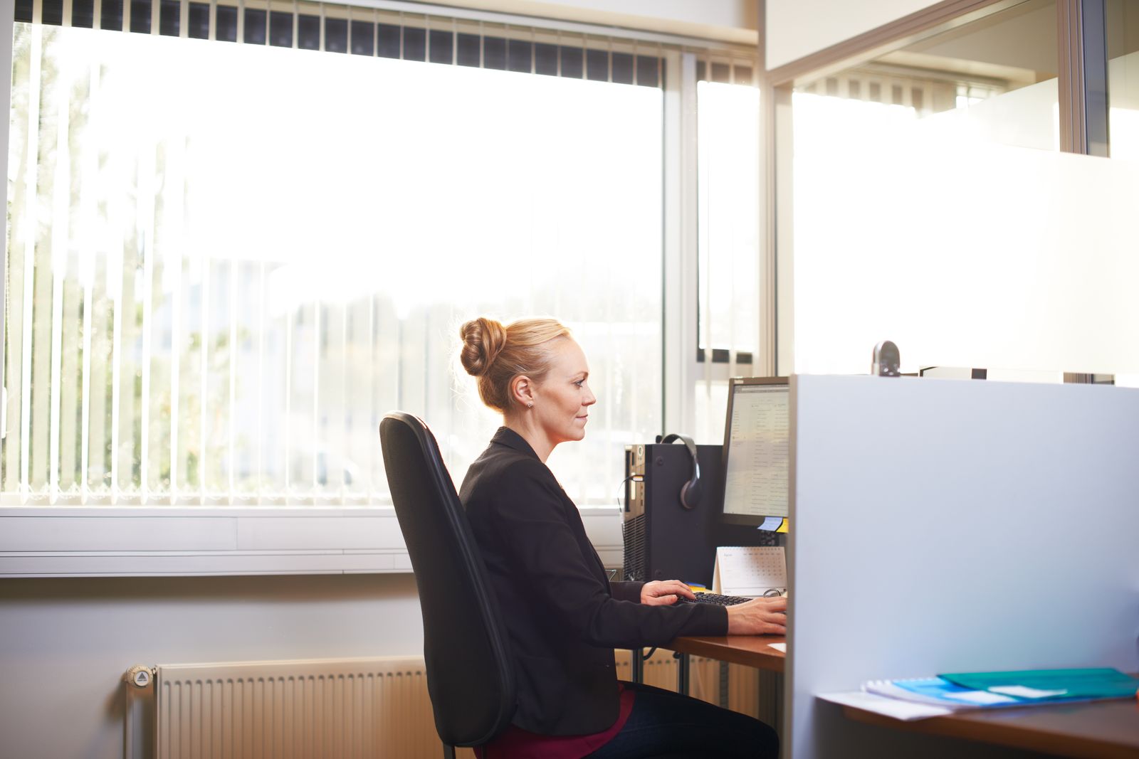 Une employée travaille sur son ordinateur dans un bureau lumineux
